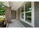 Covered front porch of home featuring brick pillar and neutral color palette at 1962 Briar Chapel Pkwy, Chapel Hill, NC 27516