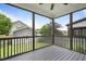 View from the screened-in porch overlooking the spacious backyard with lush lawn, stone pathway, and detached garage at 1962 Briar Chapel Pkwy, Chapel Hill, NC 27516