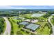 Aerial view of lush green tennis courts, pickle ball court, a pond and mature trees at 1962 Briar Chapel Pkwy, Chapel Hill, NC 27516