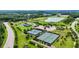 Aerial view of multiple tennis courts, a pond and green trees at 1962 Briar Chapel Pkwy, Chapel Hill, NC 27516