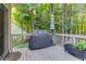 Outdoor back deck featuring a grill, a shade umbrella, wooded views and an outdoor planter at 200 Holly Branch Dr, Holly Springs, NC 27540
