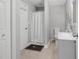 Cozy bathroom featuring a shower with curtain, a vanity with sink and a toilet with neutral colored tile flooring at 200 Holly Branch Dr, Holly Springs, NC 27540