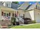 Inviting front of house with a covered porch, American flag, and attractive landscaping enhancing curb appeal at 200 Holly Branch Dr, Holly Springs, NC 27540