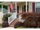 Welcoming porch featuring a decorated front door, American flag, and tasteful landscaping at 200 Holly Branch Dr, Holly Springs, NC 27540