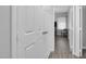Hallway with a view into a sunlit room, showcasing modern gray walls and wood-look flooring at 200 Holly Branch Dr, Holly Springs, NC 27540