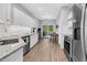 Modern kitchen with white cabinets, stainless steel appliances, and access to backyard deck at 200 Holly Branch Dr, Holly Springs, NC 27540