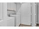 Efficient laundry room with white cabinets, a washer/dryer unit, and wood-look flooring at 200 Holly Branch Dr, Holly Springs, NC 27540