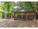 A partially-covered chicken coop with access to the yard and trees at 2009 Carolina Ave, Durham, NC 27705