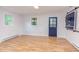 Spacious living room featuring wood floors, a blue door, and natural light from two windows at 2009 Carolina Ave, Durham, NC 27705