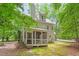 Picturesque backyard with a screened-in porch, lush greenery, and a charming stone pathway at 201 Cobblestone Dr, Chapel Hill, NC 27516