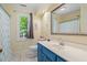 Well-lit bathroom features a vanity with blue cabinets, a toilet, and shower with tub at 201 Cobblestone Dr, Chapel Hill, NC 27516