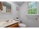 Well-lit bathroom features a single sink vanity, a window with green view, and shower with tub at 201 Cobblestone Dr, Chapel Hill, NC 27516