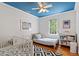 A charming bedroom is highlighted by a blue ceiling, hardwood floors, and lots of light at 201 Cobblestone Dr, Chapel Hill, NC 27516