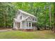 Lovely home showcasing a well-maintained lawn, mature trees, and a side entry porch with white railings at 201 Cobblestone Dr, Chapel Hill, NC 27516