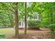 Inviting home nestled among mature trees, featuring a charming bay window and a landscaped front yard at 201 Cobblestone Dr, Chapel Hill, NC 27516