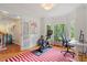 Sunlit office with large windows, exercise equipment, and hardwood floors at 201 Cobblestone Dr, Chapel Hill, NC 27516
