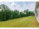 Expansive backyard featuring a gentle slope, well-maintained lawn, and mature trees at 202 E Painted Way, Clayton, NC 27527