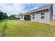 Spacious backyard with a covered patio, lush green lawn, and a privacy fence at 202 E Painted Way, Clayton, NC 27527