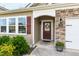 Close-up of a charming front entrance with a wreath, stone accents, and a well-kept landscape at 202 E Painted Way, Clayton, NC 27527