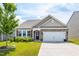 Well-maintained home featuring stone accents, a two-car garage, and a neatly landscaped front yard at 202 E Painted Way, Clayton, NC 27527