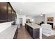 Open-concept kitchen flowing into the living area, featuring granite countertops and dark cabinets at 202 E Painted Way, Clayton, NC 27527