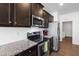 Stylish kitchen with stainless steel appliances, granite counters, and dark wood cabinetry at 202 E Painted Way, Clayton, NC 27527
