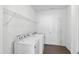 A bright laundry room with a washer, dryer, and shelving at 202 E Painted Way, Clayton, NC 27527