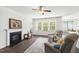 Cozy living room featuring a fireplace, comfortable seating, and large windows with natural light at 202 E Painted Way, Clayton, NC 27527