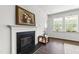 Stylish fireplace with a decorative mantle and art, with hardwood floors and natural light streaming through the windows at 202 E Painted Way, Clayton, NC 27527