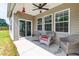 Covered patio with wicker chairs and ceiling fan at 202 E Painted Way, Clayton, NC 27527
