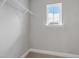 Bright walk-in closet offering practical storage solutions with shelving and a natural light filled window at 226 Faith Avenue, Sanford, NC 27330