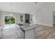 Bright kitchen features a granite island, stainless steel appliances, and an open floor plan with luxury vinyl plank flooring at 226 Faith Avenue, Sanford, NC 27330