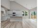 Bright kitchen with luxury vinyl plank flooring, white cabinets, granite counters, stainless steel appliances, and patio access at 226 Faith Avenue, Sanford, NC 27330