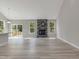Spacious living room with a stone fireplace, large windows, luxury vinyl plank flooring, and access to the patio at 226 Faith Avenue, Sanford, NC 27330
