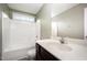 Bathroom with a shower-tub combo, light green walls, and a dark vanity at 2309 King Malcolm Ln, Zebulon, NC 27597