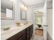 Bathroom with double sinks, dark cabinets, and view to the bedroom at 2309 King Malcolm Ln, Zebulon, NC 27597