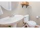 Half bathroom featuring pedestal sink, wood floors, and decorative shelf at 2309 King Malcolm Ln, Zebulon, NC 27597