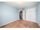 Bedroom featuring light-blue walls, carpet floors, and a double door closet at 2309 King Malcolm Ln, Zebulon, NC 27597