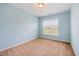 Bedroom showcasing a light-blue paint scheme, carpet flooring, and a window at 2309 King Malcolm Ln, Zebulon, NC 27597