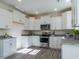 Well-lit kitchen featuring sleek white cabinets, stainless steel appliances, and granite countertops at 233 Steel Spring Rd # 24, Angier, NC 27501