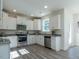 Modern kitchen with white cabinetry, stainless appliances, and granite countertops, open to dining area at 233 Steel Spring Rd # 24, Angier, NC 27501