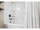 A full bathtub and shower combination with a white shower curtain, and black fixtures at 238 Lynchwick Ln, Durham, NC 27703