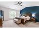Primary bedroom with a blue accent wall, ceiling fan, and natural light from a large window at 238 Lynchwick Ln, Durham, NC 27703