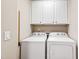 Bright laundry room featuring white cabinets and modern washer and dryer at 238 Lynchwick Ln, Durham, NC 27703