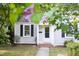 Quaint bungalow featuring grey siding, black shutters, and well-manicured lawn at 2423 Farthing St, Durham, NC 27704