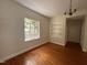 Bedroom featuring hardwood floors, natural light, and built-in shelving for extra storage at 2428 Perkins Rd, Durham, NC 27705