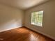 Bright bedroom featuring hardwood floors and a sunlit window offering outside views at 2428 Perkins Rd, Durham, NC 27705