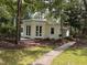 Charming home featuring a light yellow brick exterior, elegant white trim, and lush landscaping at 2428 Perkins Rd, Durham, NC 27705