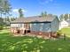 A spacious backyard features a charming deck, well-maintained lawn, and mature landscaping perfect for relaxing or entertaining at 244 Lasswade Ct, Zebulon, NC 27597