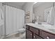A well-lit bathroom features a shower, toilet, and a modern vanity with a dark wood finish and a framed mirror at 244 Lasswade Ct, Zebulon, NC 27597